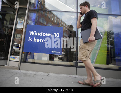 Un homme marche d'un chanter la nouvelle publicité Microsoft Windows 10 dans la ville de New York le 29 juillet 2015. Windows 10 mise à jour gratuite est disponible de 190 pays aujourd'hui. C'est la plus grande mise à jour de Windows en années et représente un certain nombre de nouvelles orientations pour Microsoft's premier produit logiciel. Windows 10 Windows remplace 8 et 8.1. Photo de John Angelillo/UPI Banque D'Images