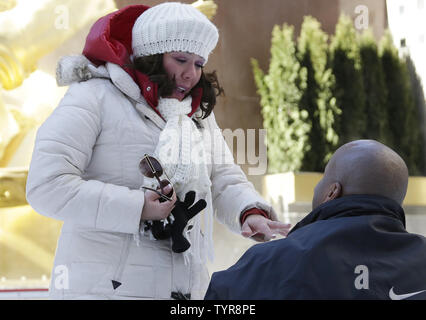 Jolson Orane prend un genou et tenant une bague de fiançailles est une proposition de mariage à Alexis Mendoza dans la patinoire du Rockefeller Center sur la Saint Valentin à New York City le 14 février 2016. Photo de John Angelillo/UPI Banque D'Images