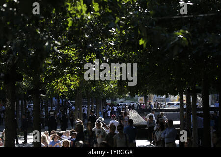 En deuil et les hommes en uniforme recueillir et déposer des fleurs à l'des bassins à l'9/11 Memorial près de One World Trade Center sur le 15e anniversaire des attaques terroristes sur le World Trade Center à Ground Zero à New York, le 11 septembre 2016. Photo de John Angelillo/UPI Banque D'Images