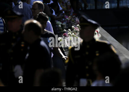 En deuil et les hommes en uniforme recueillir et déposer des fleurs à l'des bassins à l'9/11 Memorial près de One World Trade Center sur le 15e anniversaire des attaques terroristes sur le World Trade Center à Ground Zero à New York, le 11 septembre 2016. Photo de John Angelillo/UPI Banque D'Images