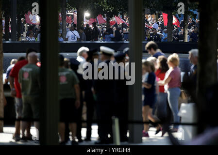 En deuil et les hommes en uniforme recueillir et déposer des fleurs à l'des bassins à l'9/11 Memorial près de One World Trade Center sur le 15e anniversaire des attaques terroristes sur le World Trade Center à Ground Zero à New York, le 11 septembre 2016. Photo de John Angelillo/UPI Banque D'Images