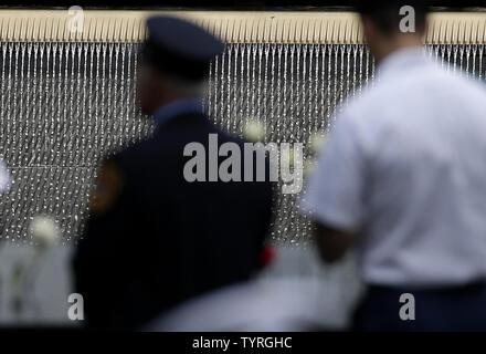 En deuil et les hommes en uniforme recueillir et déposer des fleurs à l'des bassins à l'9/11 Memorial près de One World Trade Center sur le 15e anniversaire des attaques terroristes sur le World Trade Center à Ground Zero à New York, le 11 septembre 2016. Photo de John Angelillo/UPI Banque D'Images