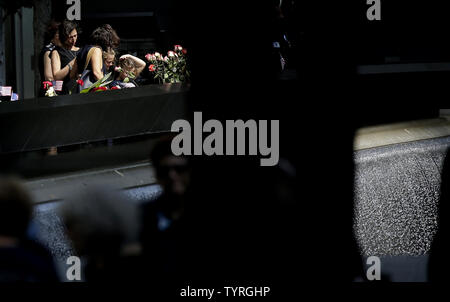 En deuil et les hommes en uniforme recueillir et déposer des fleurs à l'des bassins à l'9/11 Memorial près de One World Trade Center sur le 15e anniversaire des attaques terroristes sur le World Trade Center à Ground Zero à New York, le 11 septembre 2016. Photo de John Angelillo/UPI Banque D'Images