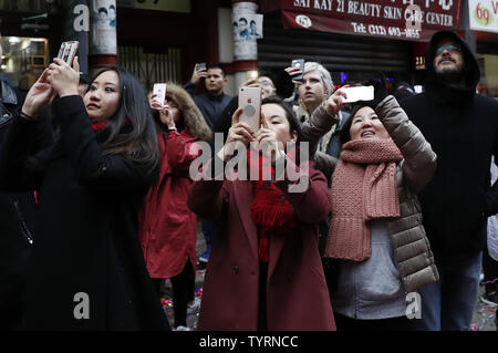 Un groupe de fêtards prendre des photos de onfetti dans l'air à l'occasion de la Nouvelle Année lunaire chinoise dans le Chinatown de New York City le 28 janvier 2017. Autour du monde, les gens célèbrent la fête la plus importante dans le calendrier chinois. Célébrations varient selon l'endroit où ils sont détenus, mais cette année, les couleurs de la chance sont l'or, brun et jaune qui sont associés à l' animal qui est 2017le coq. Photo de John Angelillo/UPI Banque D'Images