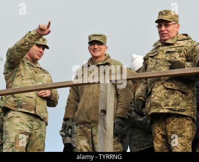 Le colonel Nick Ducich, commandant de la formation Group-Ukraine multinationales points à la formation des soldats de l'armée tout en parlant à général Curtis Scaparrotti, U.S. European Command, et le lieutenant général Pavlo Tkachuk, commandant de l'Académie des forces terrestres, le 23 novembre 2016 au Centre international de maintien de la paix et la sécurité dans l'viv, Ukraine. Ducich se prépare à abandonner le commandement de la 45e Brigade d'infanterie, l'équipe de combat hors de New York, qui va reprendre l'entraînement en janvier. JMTG-U est l'objectif principal est de former directement les soldats ukrainiens à court terme tout en aidant la terre ukrainienne Fo Banque D'Images