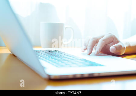 L'homme se sert de l'ordinateur portable sur table Banque D'Images