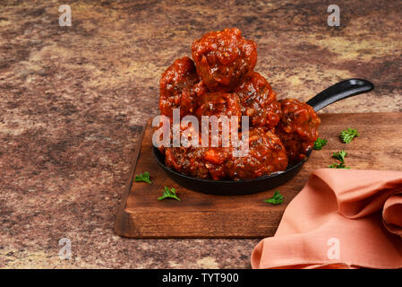 Les boulettes de couverts à la sauce tomate dans la poêle en fonte Banque D'Images