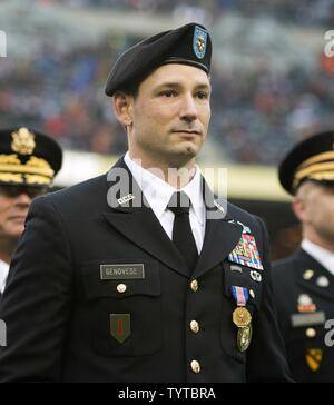 La Garde nationale de l'Illinois candidat Agent Tony Genovese, de Chicago, est à l'attention et est reconnu par la foule après avoir reçu la Médaille des soldats au cours de l'ours de Chicago à 'Salute' Service 27 novembre jeu à Soldier Field, à Chicago. Genovese a été reconnu pour sa bravoure dans l'extraction d'un conducteur d'un véhicule à la suite d'un accident le 11 mai 2016. Banque D'Images