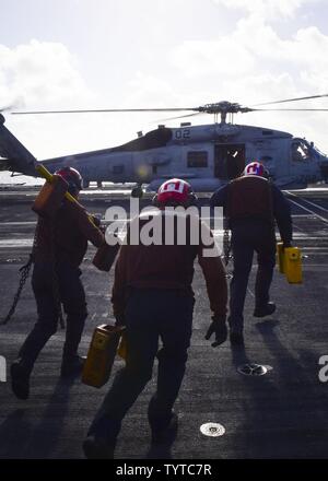 Océan Pacifique (nov. 27, 2016) - Les marins affectés à l'hélicoptère de combat Eightballers Mer Escadron (HSC) 8 courir pour caler une chaîne et Sea Hawk MH-60S'hélicoptère sur le pont d'envol du porte-avions USS Nimitz (CVN 68). Nimitz est actuellement en cours la conduite du navire, la disponibilité de la formation sur mesure et l'évaluation finale Problème (TSTA/FEP), qui évalue l'équipage sur leur rendement au cours des exercices de formation et des scénarios du monde réel. Une fois terminée, TSTA Nimitz/FEP ils commenceront Conseil d'Inspection et enquête (INSURV) et l'unité de formation Composite (Exercice COMPTUEX) en préparation d'un u Banque D'Images