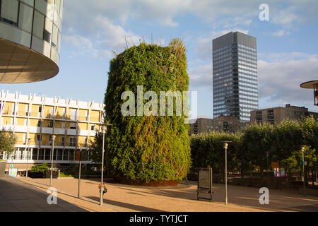 Paris, France - 10 juillet 2018 : grand lit de fleur avec des arbres verts à côté d'une tour moderne en verre des gratte-ciel et ciel bleu backgroundin le district de Banque D'Images