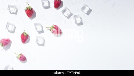 Des fraises fraîches avec des cubes de glace sur fond blanc Banque D'Images