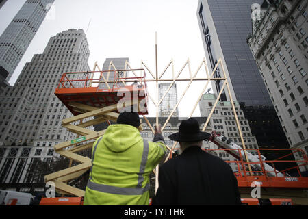 Un travailleur et directeur de l'organisation de jeunesse Lubavitch Parrain du plus grand monde Rabbi Shmuel Menorah Butman regardez comme assemblée de la plus grande Menorah conclut dans célébration de Hanoucca (Hanoukka) à l'extérieur de l'hôtel Plaza sur la 5e Avenue à New York le 30 novembre 2018. La menorah est certifié par Guinness World Records comme le plus grand. Photo de John Angelillo/UPI Banque D'Images