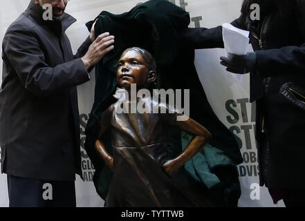 La jeune fille intrépide statue est dévoilé à son nouvel emplacement à l'extérieur de la bourse avant l'ouverture d'une sonnerie au New York Stock Exchange sur Wall Street à New York City le 10 décembre 2018. La statue en bronze d'une jeune fille debout avec ses mains sur ses hanches a été déplacé à l'université Bowling Green Park, où elle se tenait à travers l'emblématique "en charge Bull' pour plus d'un an, à une place à l'extérieur de la Bourse de New York. Le bureau du maire de New York a déclaré en avril que la statue est de poster à l'extérieur de la bourse serait son 'long terme' accueil. Photo de John Angelillo/UPI Banque D'Images