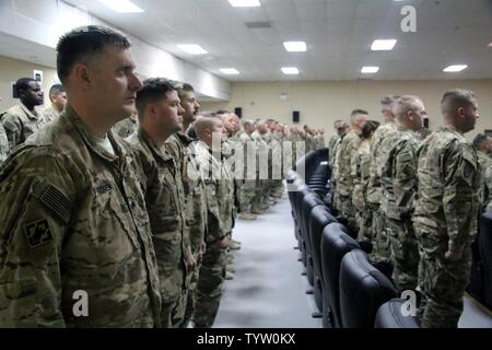 Soldats assigné à la force de la granit 368Fr. Bn. stand à l'attention pendant la première sous-officier du bataillon de la cérémonie qui signifie le passage d'un soldat enrôlé au grade de sergent dans le corps des sous-officiers au Camp Arifjan, au Koweït, le 29 novembre 2016. Banque D'Images