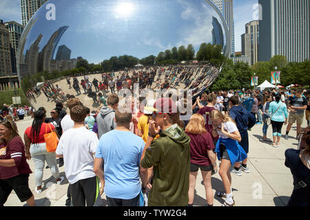 Groupes de jeunes visiteurs et touristes de Millennium Park un samedi matin en été prendre des photos et vos autoportraits près de la Cloud Gate bean Banque D'Images