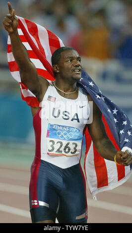 Justin Gatlin des USA vagues le drapeau après avoir remporté l'or dans l'épreuve du 100m finale dans le stade olympique au Jeux Olympiques d'été de 2004 à Athènes, le 22 août 2004. (UPI Photo/ Claus Andersen) Banque D'Images