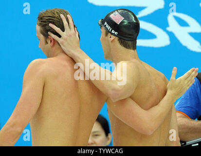 USA's Michael Phelps promenades sur la terrasse de la piscine avec son coéquipier Ian Crocker après Phelps prit sa 7e médaille d'or chez les hommes 100m papillon finale au Centre aquatique national (Cube d'eau) pendant les Jeux Olympiques d'été de 2008 à Beijing, Chine, le 16 août 2008. Phelps est à égalité avec Mark Spitz, le nageur qui décroche le record de 7 médailles d'or olympiques en une seule à Munich, 1972. Crocker a terminé 4e dans la course. (Photo d'UPI/Roger L. Wollenberg) Banque D'Images