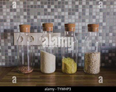 Dans les banques de céréales dans la cuisine des récipients en verre sur l'arrière-plan d'une table en bois Banque D'Images