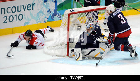 La Suisse Roman Wick joue la rondelle sur la glace en tant que gardien des USA Ryan Miller et Jack Johnson des USA pour se défendre au cours de la troisième période en jeu 1 des quarts de finale à Place Hockey du Canada à Vancouver, Canada, durant les Jeux Olympiques d'hiver de 2010 le 24 février 2010. USA a battu la Suisse 2-0, de passer à la demi-finale. UPI/Roger L. Wollenberg Banque D'Images