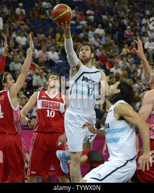 Andres Nocioni de l'Argentine (C) disques durs au cours des défenseurs russes panier (L-R) Alexey Schved et Victor Khryapa comme coéquipier Luis Scola permet (R) au cours de l'Argentina-Russia Men's Basketball match pour la Médaille de Bronze au Jeux Olympiques d'été de 2012, le 12 août 2012, à Londres, en Angleterre. UPI/Mike Theiler Banque D'Images