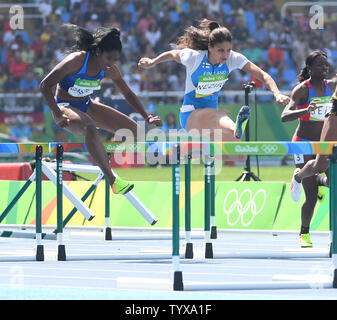 USA's Kristi Castlin (L) et le Finlandais Nooralotta Neziri race dans la première épreuve de la Women's 100m haies aux Jeux Olympiques d'été de Rio 2016 à Rio de Janeiro, Brésil, le 16 août 2016. Photo par Terry Schmitt/UPI Banque D'Images