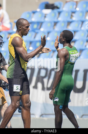 Usain Bolt de la Jamaïque félicite la deuxième place Ejowvokoghene Oduduru du Nigeria à la suite du 200m masculin 1 Ronde 9 La chaleur dans le stade olympique au Jeux Olympiques de Rio 2016 à Rio de Janeiro, Brésil, le 16 août 2016. La chaleur a remporté le boulon avec un temps de 20.28. Photo de Richard Ellis/UPI Banque D'Images