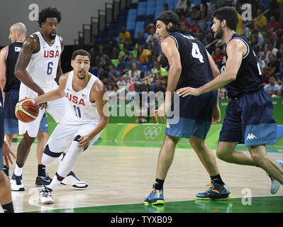 United States' Klay Thompson (L) a l'air de dribbler passé l'Argentine Luis Scola ($) et Patricio Garino au cours de la France contre l'Argentine Men's en quart de jeu de basket-ball à la Rio 2016 Jeux Olympiques d'été à Rio de Janeiro, Brésil, le 17 août 2016. Les États-Unis ont gagné, 105-78 et est à la recherche de répéter avec une médaille d'or après avoir remporté de Beijing (2008) et de Londres (2012). Photo de Mike Theiler/UPI Banque D'Images