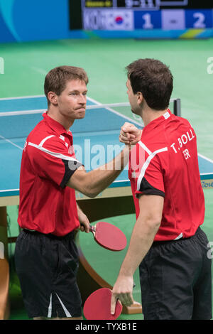 Bastian Steger, gauche, félicite son coéquipier Timo Boll après avoir remporté leur match contre l'équipe de la Corée du Sud, l'équipe masculine du Tennis de Table pour la médaille de bronze au Riocentro Pavilion 3 au Jeux Olympiques d'été de Rio 2016 à Rio de Janeiro, Brésil, le 17 août 2016. L'Allemagne a remporté la médaille de bronze 3-1. Photo de Richard Ellis/UPI Banque D'Images