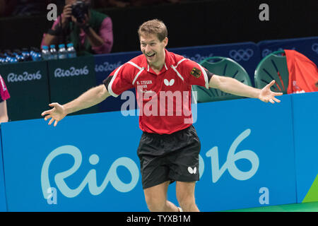 Bastian Steger d'Allemagne se précipite sur à la cour pour rejoindre son coéquipier Timo Boll pour célébrer après avoir battu la Corée du Sud, l'équipe masculine de tennis de table pour la médaille de bronze au Riocentro Pavilion 3 au Jeux Olympiques d'été de Rio 2016 à Rio de Janeiro, Brésil, le 17 août 2016. L'Allemagne a gagné la médaille de bronze en battant 3-1 La Corée du Sud. Photo de Richard Ellis/UPI Banque D'Images