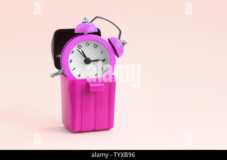 Perdre du temps concept. Réveils Rose Corbeille en plastique sur la pêche de fond. Mauvaise gestion du temps et du mal Banque D'Images