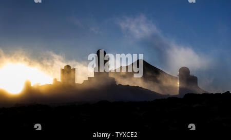 Coucher du soleil avec brouillard et les nuages autour des télescopes astronomiques. Le Mont Teide en arrière-plan Banque D'Images