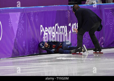 Les fonctionnaires effectuent pour vérifier la voie numéro un mondial de la Elise Christie de Grande-Bretagne après avoir sauté sur la glace sur le dernier virage de quart de finale dans les dames 1500m de patinage de vitesse sur courte piste au cours de la finale des Jeux Olympiques d'hiver de 2018 à Pyeongchang, à l'Ice Arena à Gangneung Gangneung, Corée du Sud, le 17 février 2018. Photo de Richard Ellis/UPI Banque D'Images