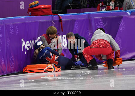 Les fonctionnaires effectuent pour vérifier la voie numéro un mondial de la Elise Christie de Grande-Bretagne après avoir sauté sur la glace sur le dernier virage de quart de finale dans les dames 1500m de patinage de vitesse sur courte piste au cours de la finale des Jeux Olympiques d'hiver de 2018 à Pyeongchang, à l'Ice Arena à Gangneung Gangneung, Corée du Sud, le 17 février 2018. Photo de Richard Ellis/UPI Banque D'Images