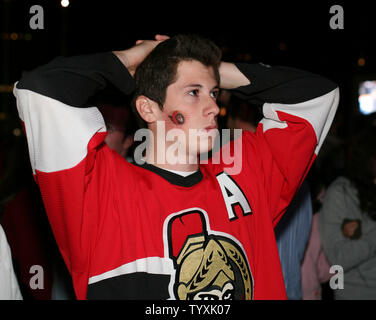 Un ventilateur des Sénateurs d'Ottawa le découragement et le regarde prendre quatre buts au cours de la fin de la troisième période de cinq jeux de la finale de la Coupe Stanley le 6 juin 2007. Plus de dix mille fans se sont réunis pour regarder le match à la Place des festivals à l'extérieur de l'Hôtel de Ville d'Ottawa sur deux grands écrans avec l'espoir de ramener la Coupe Stanley de retour à Ottawa après 80 ans. Les canards a remporté la coupe avec un score de 6-2. (Photo d'UPI/Grace Chiu). Banque D'Images