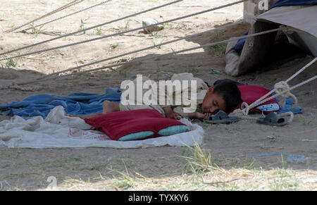 Un jeune garçon pakistanais qui peut accueillir près d'une tente au camp de réfugiés de Lahore, Pakistan, Swabi Le 25 mai 2009. Les militaires pakistanais a déclaré lundi qu'elle était confrontée à une résistance 'stiff' comme il a lutté pour arracher la vallée de Swat des mains des Taliban, dans une offensive qui a maintenant dispersés 2,38 millions de civils. (Photo d'UPI/Sajjad Ali Qureshi) Banque D'Images