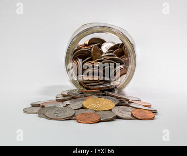 Pièces de change jar portant sur le côté avec coins spilling out Banque D'Images