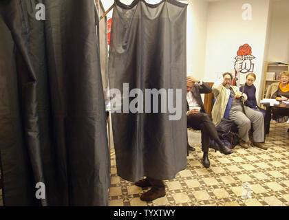 Membre du Parti socialiste français voix derrière un stand comme d'autres attendent au cours de la primaire du parti pour la prochaine élection présidentielle française à Paris, le 16 novembre 2006. Trois candidats, Ségolène Royal, Dominique Strauss-Khan et Laurent Fabius, sont en lice pour diriger le parti socialiste à la prochaine élection présidentielle française. (Photo d'UPI/Eco Clement) Banque D'Images