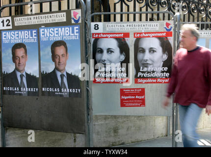 Un résident marche dernières affiches électorales pour les prochaines élections présidentielles de 2007 montrant candidat de droite Nicolas Sarkozy et Ségolène Royal socialiste à Paris le 9 avril 2007. La campagne officielle des élections présidentielles en France le coup d'aujourd'hui, deux semaines avant le premier tour de scrutin, avec Sarkozy et Royal comme les favoris dans les sondages. (Photo d'UPI/Eco Clement) Banque D'Images