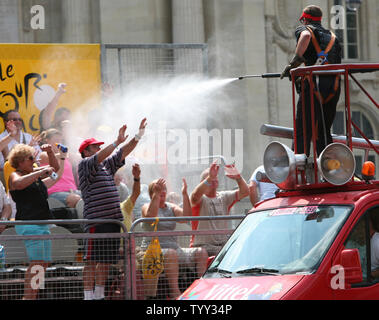 Un membre de la caravane de l'eau surchauffée pulvérisations sur fans le long de l'Avenue des Champs-Élysées lors de la dernière étape du Tour de France à Paris le 27 juillet 2008. Carlos Sastre de l'Espagne, déjà été cinq fois top-ten de finition de la course, a remporté l'épreuve pour la première fois. (UPI Photo/ David Silpa) Banque D'Images