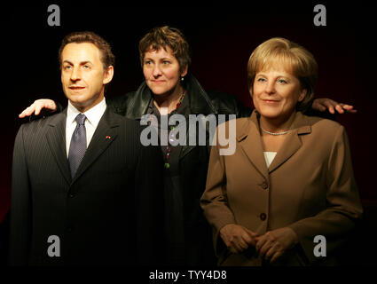 Un visiteur pose entre le passé la cire de la Chancelière allemande Angela Merkel (R), et le président français Nicolas Sarkozy à l'affiche au Musée Grévin à Paris, le 29 avril 2009. Merkel's double a été inauguré aujourd'hui. (Photo d'UPI/Eco Clement) Banque D'Images