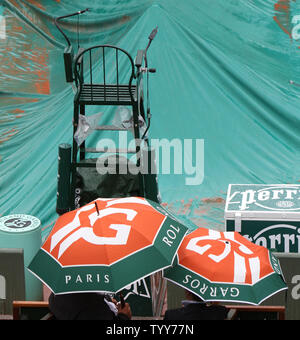 Deux spectateurs s'asseoir sous les parasols pendant un Rain Delay à l'Open de France de Roland Garros à Paris le 27 mai 2010. UPI/David Silpa Banque D'Images