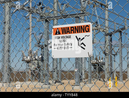 Panneau d'avertissement de tension élevée montrant danger d'électrocution entourant un poste électrique fournissant de l'électricité Banque D'Images