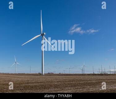 Windmill farm avec sous-station électrique et des lignes de transmission en arrière-plan dans le Midwest, l'Illinois. Bule sky with white clouds Banque D'Images