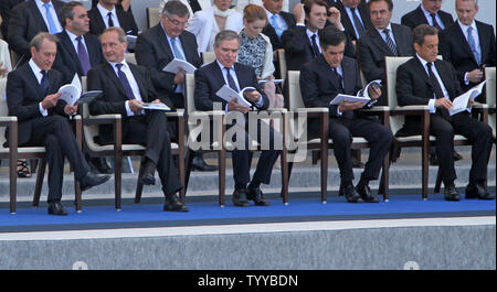 (De G à D) Le Maire de Paris Bertrand Delanoë, le ministre français de la Défense Gérard Longuet, Président de l'Assemblée nationale Bernard Accoyer, le Premier ministre français François Fillon et le président français Nicolas Sarkozy lire le programme de la cérémonie au début de la parade militaire annuelle à la place de la Concorde au cours de la fête de la Bastille à Paris le 14 juillet 2011. Le défilé de cette année a mis en relief les régiments des territoires français d'outre-mer y compris la Guadeloupe, Guyane, Martinique, Réunion, Mayotte, Nouvelle-Calédonie et Polynésie Française. UPI/David Silpa Banque D'Images