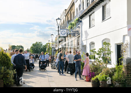 Les gens de prendre un verre au soleil en dehors de la Blue Anchor et le Rutland Arms riverside pubs sur Lower Mall, Hammersmith, London W6, England, UK Banque D'Images