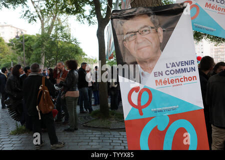 Les partisans du candidat d'extrême gauche à l'élection présidentielle française, Jean-Luc Melenchon, chat sous une affiche de campagne à la fin d'un rassemblement à Paris le 21 avril, 2017. Le candidat populiste de la coalition 'La France insoumise' (la France rebelle) a augmenté à un blocage inattendu de 18 % dans les sondages qui en font l'un des quatre concurrents sérieux pour gagner le premier tour des votes. Photo Maya UPI/Vidon-White Banque D'Images