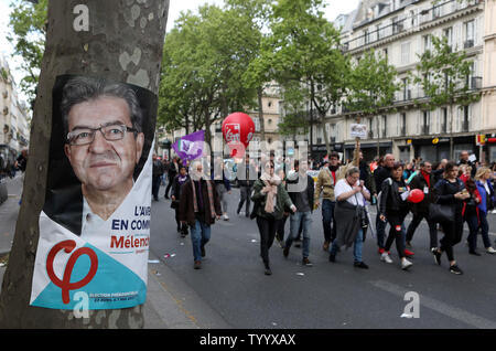 Les manifestants défilent dans les rues de Paris le jour de la fête du Travail 01 mai 2017 passé une affiche de campagne affichage politicien d'extrême gauche Jean-Luc Melenchon. Quelque 20  % ont voté pour Melenchon qui a échoué à diriger ses partisans sur l'opportunité de voter en faveur du centriste Emmanuel Macron dans les élections présidentielles de ruissellement ou s'abstenir, une décision considérée comme bénéficiant à son rival, le dirigeant du parti d'extrême droite Marine Le Pen. Photo Maya UPI/Vidon-White Banque D'Images