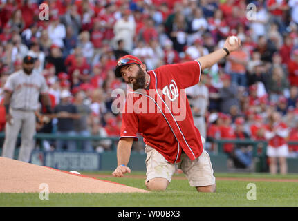 SFC ancien combattant en Afghanistan s'agenouille derrière la Brian Keaton pitchers mound et jette le premier lancer comme une grenade avant les Giants de San Francisco et Washington Nationals jeu 2 de la Division de la Ligue nationale au Parc série ressortissants à Washington, DC, le 4 octobre 2014. UPI/Pat Benic Banque D'Images