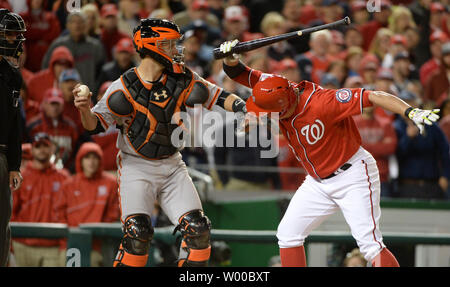 Nationals de Washington Asdrubal Cabrera (R) claque sa bat dans la frustration, appelé sur les grèves par Carapazza accueil arbitre Vic (L) comme catcher Buster Posey se prépare à lancer la balle, dans la dixième manche de jeu 2 contre les Giants de San Francisco dans la Ligue nationale au Parc Nationaux Division Series à Washington, DC, le 4 octobre 2014. Cabrera a été éjecté à plaider dans l'appel. UPI/Pat Benic Banque D'Images