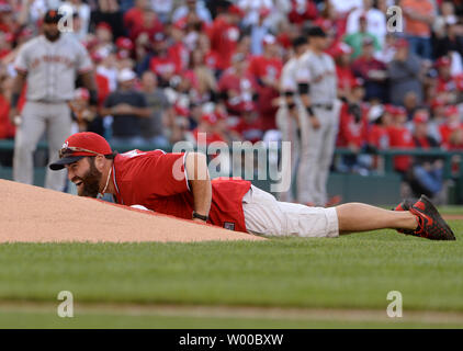 Ancien combattant en Afghanistan Brian SFC Keaton se trouve en décubitus ventral sur les pitchers mound après avoir jeter le premier lancer comme une grenade avant les Giants de San Francisco et Washington Nationals jeu 2 de la Division de la Ligue nationale au Parc série ressortissants à Washington, DC, le 4 octobre 2014. UPI/Pat Benic Banque D'Images